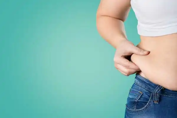 Image of woman pinching her love handles to show weight gain Prestwich